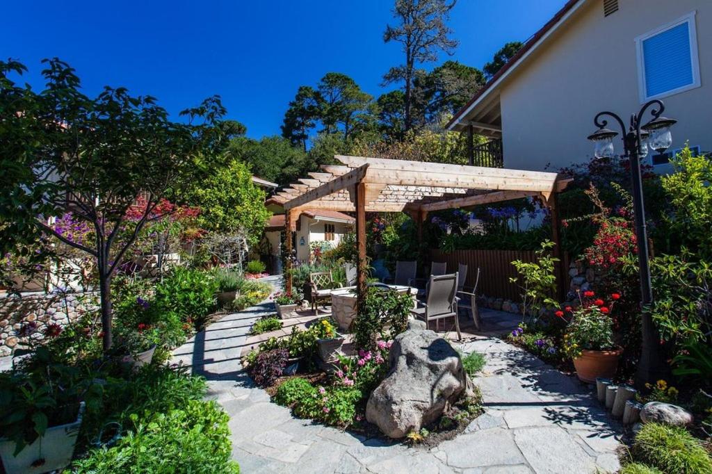 a garden with a pergola and flowers in a yard at The Vendange Carmel Inn & Suites in Carmel