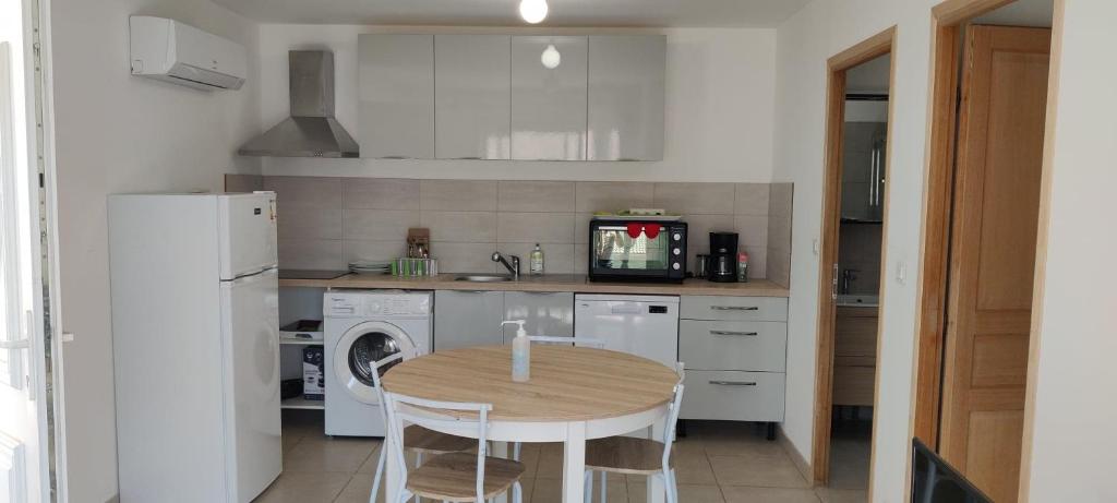 a small kitchen with a table and a refrigerator at Maison avec petite terrasse in Vescovato