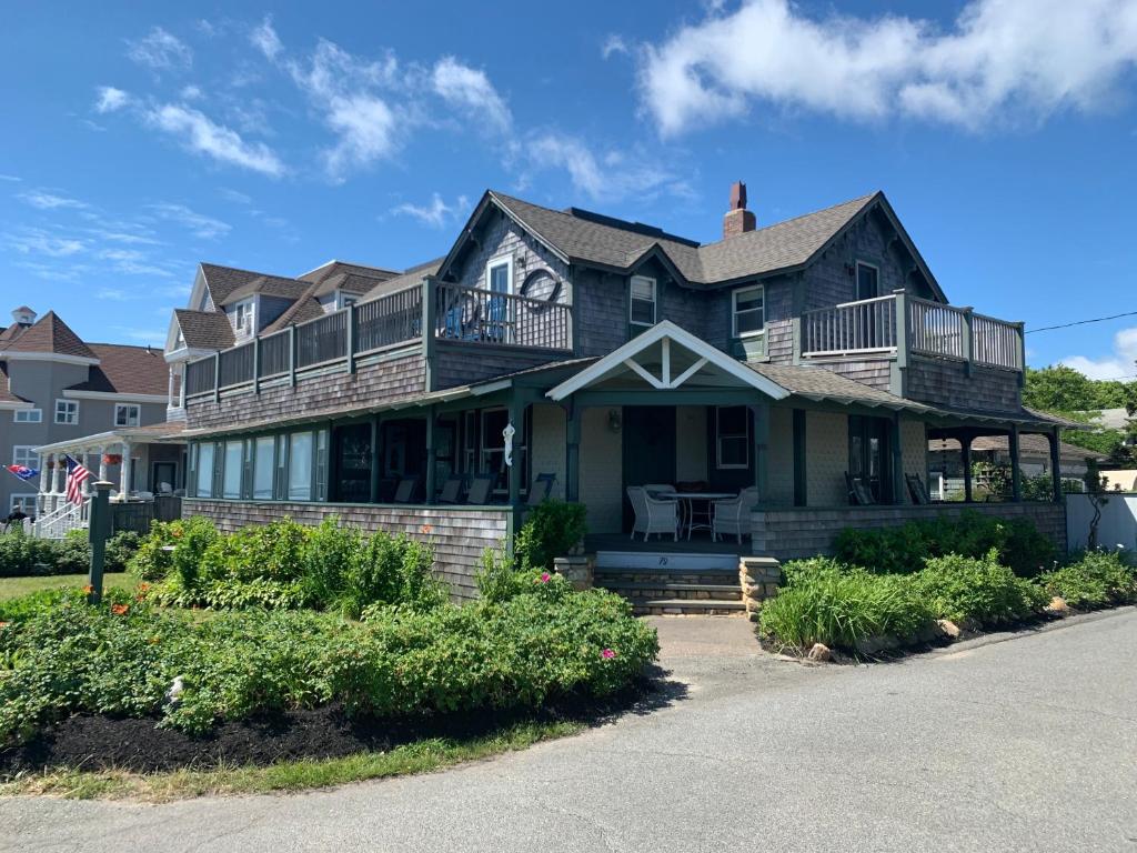 a large house with a porch and a balcony at Capricorn Beach House in Oak Bluffs