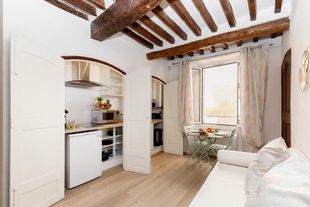Ce petit appartement est doté de murs blancs et de plafonds en bois. dans l'établissement Panisse YourHostHelper, à Cannes