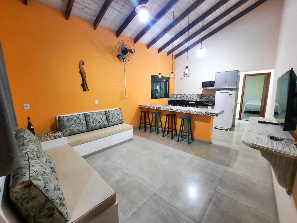 a living room with a couch and a kitchen at VILA CARRENHO in Bonito