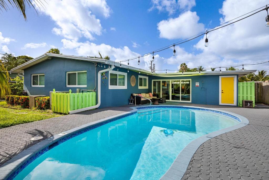 ein Haus mit einem Pool vor einem Haus in der Unterkunft Trendy 3-bedroom villa with saltwater pool and yard in Fort Lauderdale