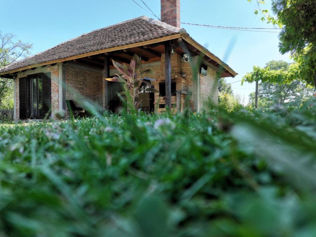 ein altes Backsteinhaus mitten im Gras in der Unterkunft Gajica konak-Orasac in Aranđelovac