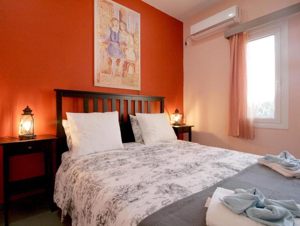a bedroom with a large bed with orange walls at Seaside, relaxing family house with playground! Villa Lavrys 4 in Marathi