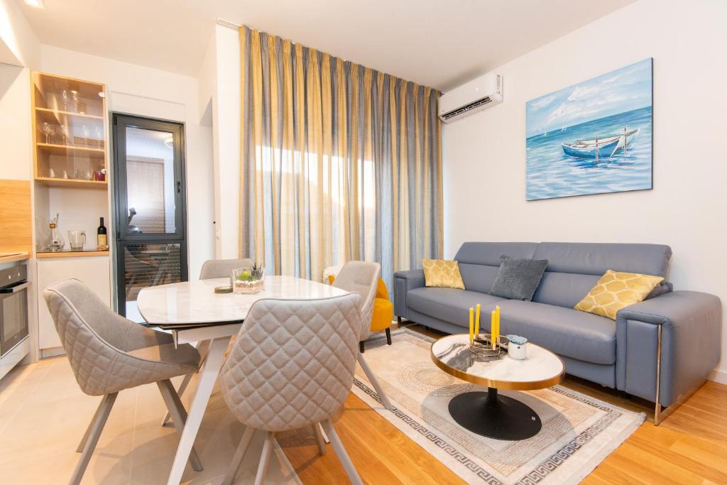 un soggiorno con divano blu e tavolo di Apartment Gardenija a Tivat