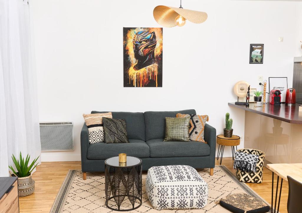 un salon avec un canapé bleu et une table dans l'établissement Appartement Wakandais-proche Disney, parking & wifi, à Montévrain