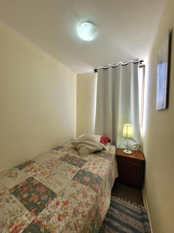 1 dormitorio con 1 cama y 1 mesa con lámpara en Atacama Valley 10, en Copiapó