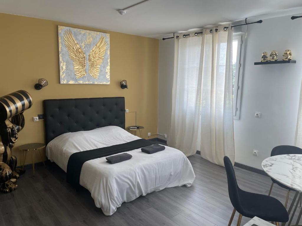 a bedroom with a bed and a table and chairs at Family Hôtel FUTUROSCOPE in Jaunay-Clan
