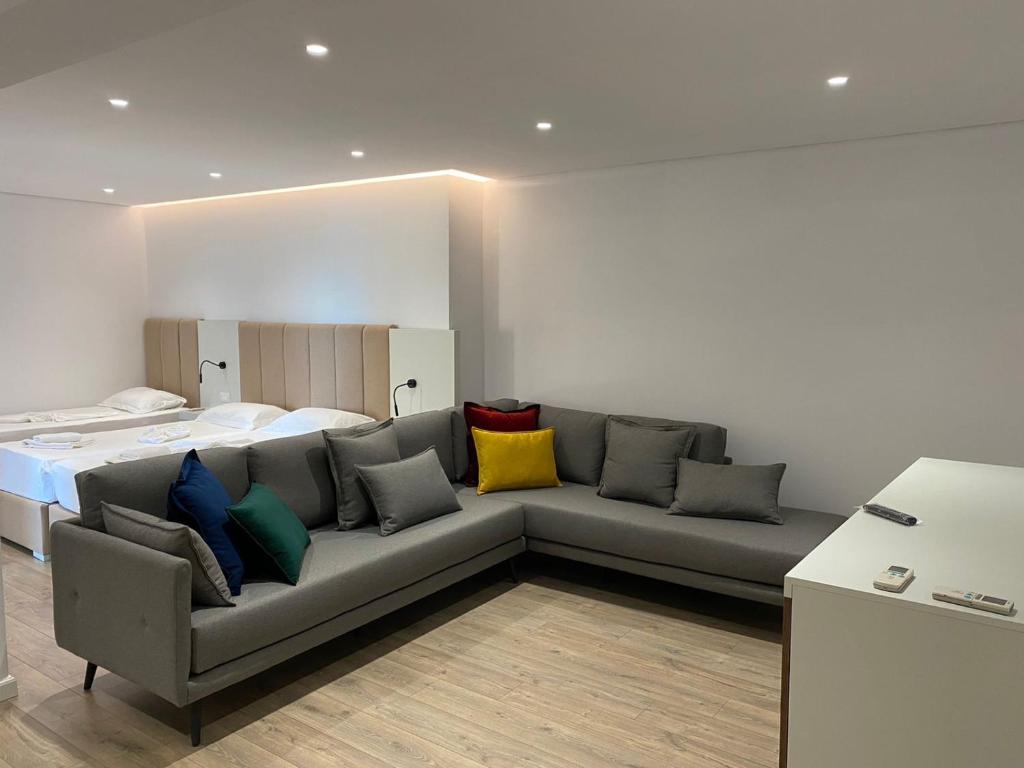ein Wohnzimmer mit einem Sofa und bunten Kissen in der Unterkunft Eval Hotel in Sarandë