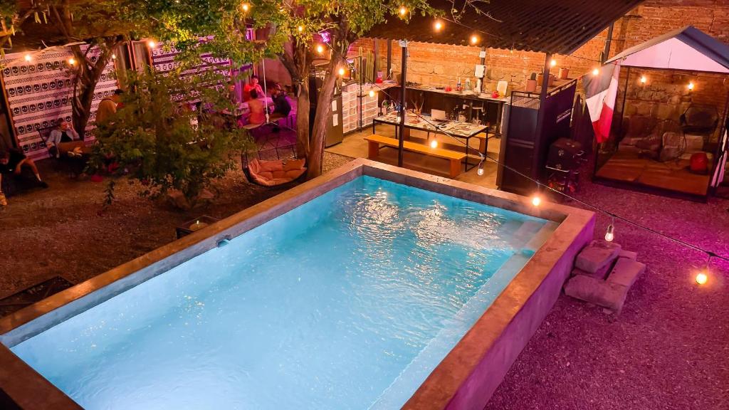 a swimming pool with a pool table and chairs at Ticuchi Hostal in Oaxaca City