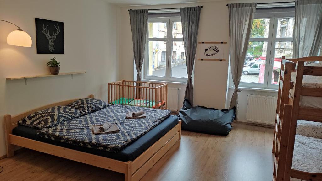 a bedroom with a bed and two windows at Apartmán Vejprty in Vejprty