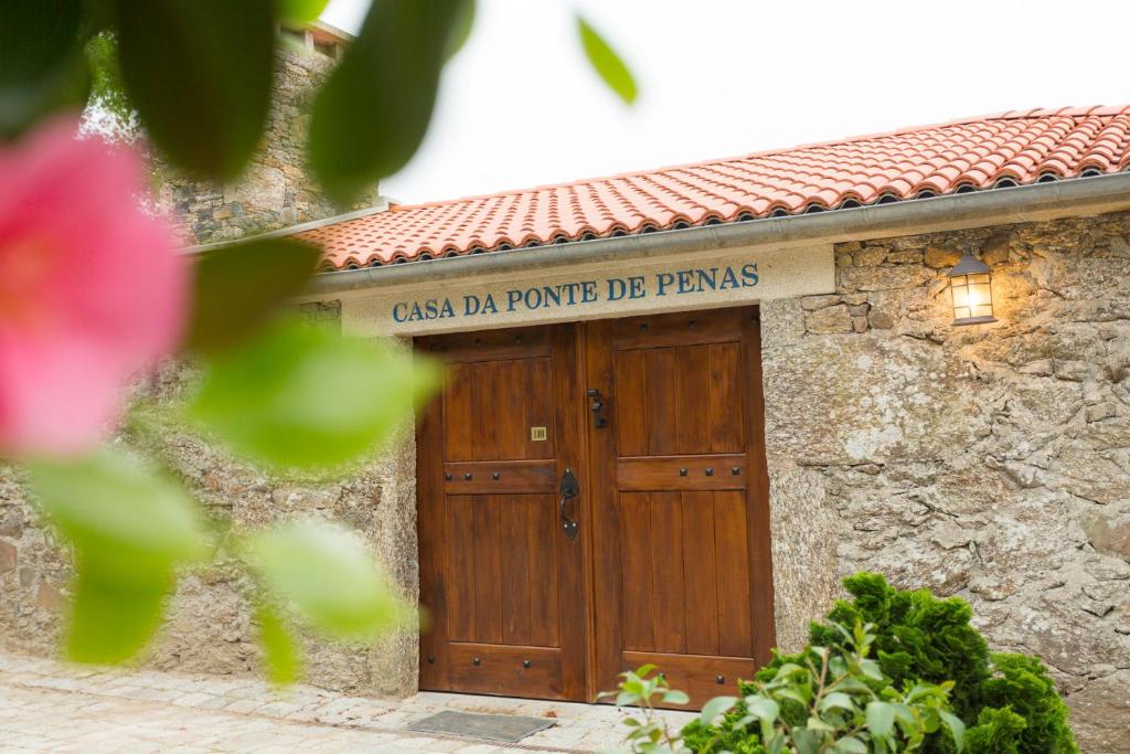 un bâtiment avec une porte en bois et un panneau. dans l'établissement Casa da Ponte de Penas, à Melide