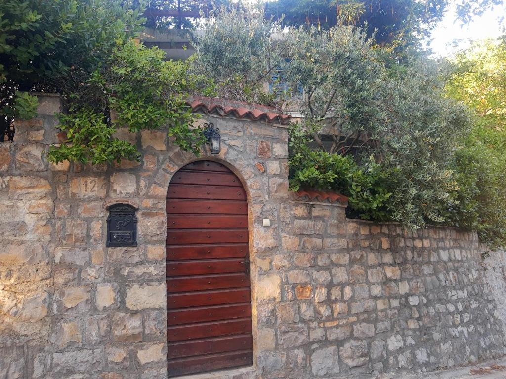Una pared de ladrillo con una puerta roja. en Sea-side Old Stone Villa with a private Garden en Budva