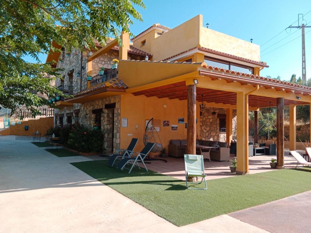 een huis met een veranda met stoelen op een gazon bij Finca Los Villegas in Castril