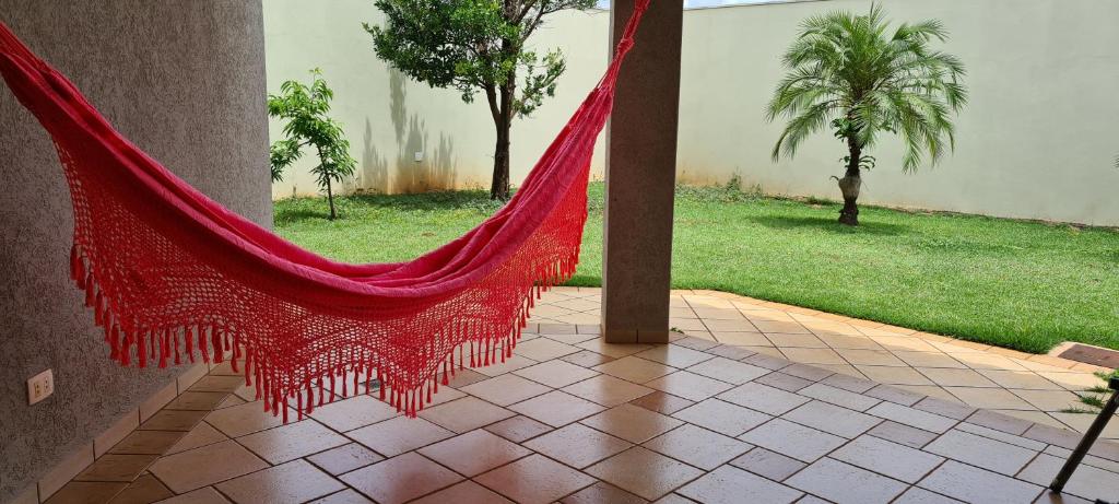 a red hammock hanging from a pole in a courtyard at Betthy's House in Campo Grande