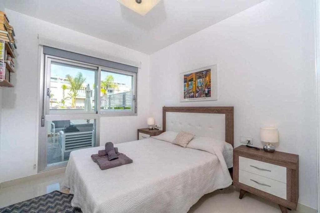 Un dormitorio con una cama con una cruz. en Espanhouse Caroline bungalow, en Torrevieja