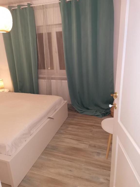 a bedroom with a bed and a blue curtain at Bloom Box Apartments in Craiova