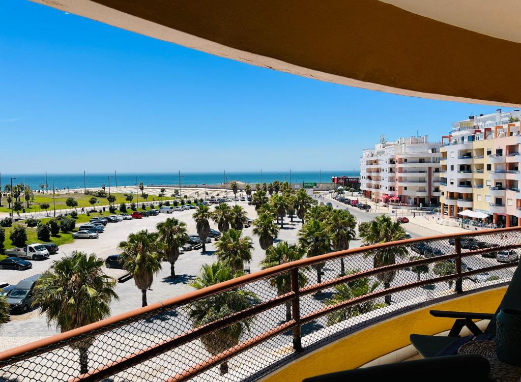 balcón con vistas a la playa y a los edificios en Casa do Mar, en Costa da Caparica