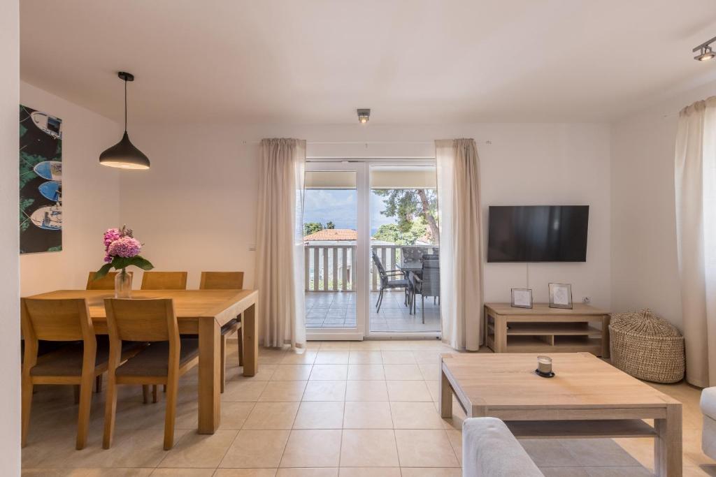a living room with a dining room table and a television at MAR Sea View Apartment in Supetar