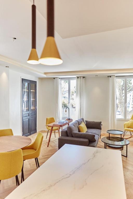 un salon avec un canapé, des tables et des chaises dans l'établissement Appartement exceptionnel avec parking Centre-ville Aix-en-Provence, à Aix-en-Provence