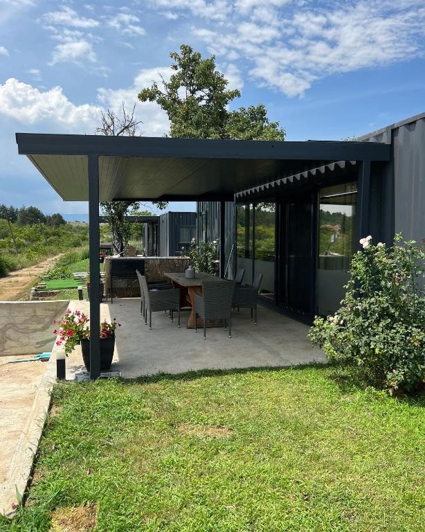 a pavilion with a table and chairs in a yard at HomeRevolution in Marikostenovo