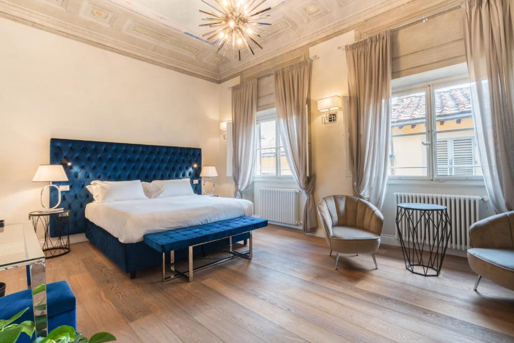 a bedroom with a blue bed and a chair at Relais Condotta in Florence