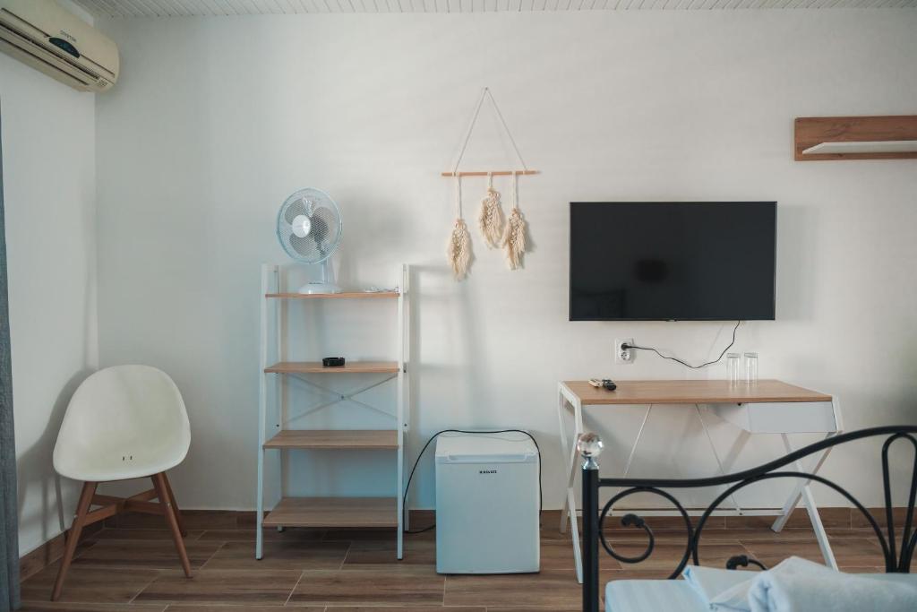 Zimmer mit einem TV, einem Schreibtisch und einem Stuhl in der Unterkunft FKK Ada Bojana in Ulcinj