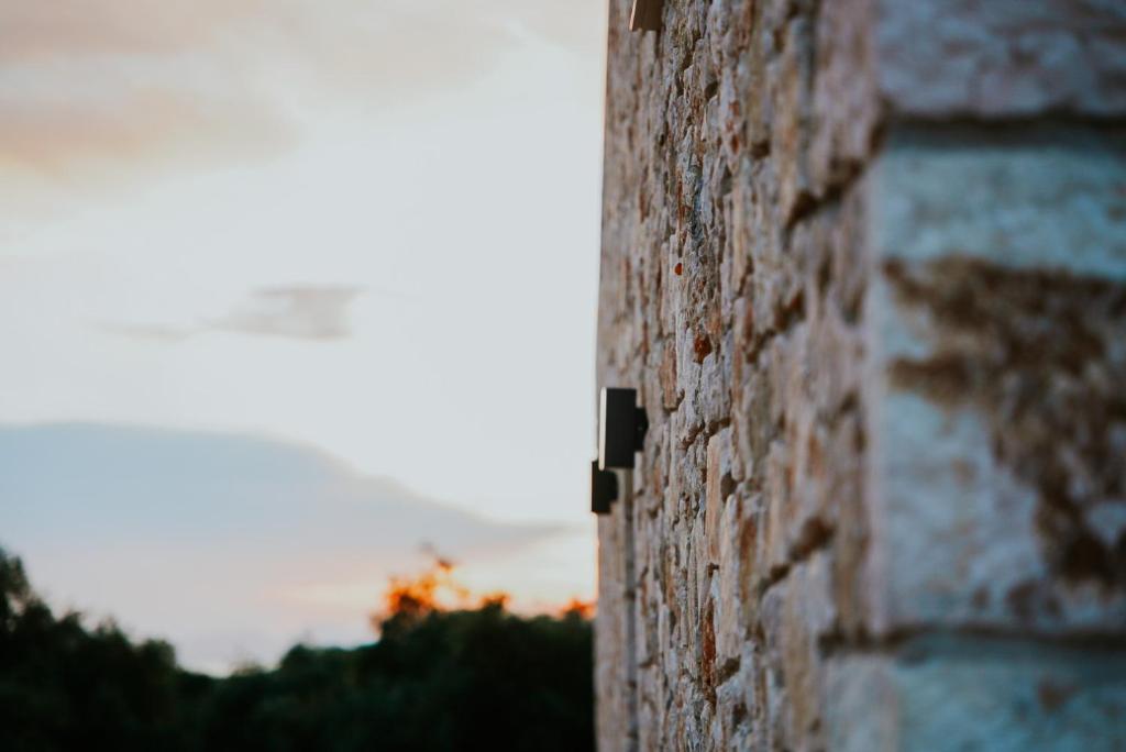 a corner of a brick wall with the sunset in the background at Elaionas Estate Perdika in Perdika