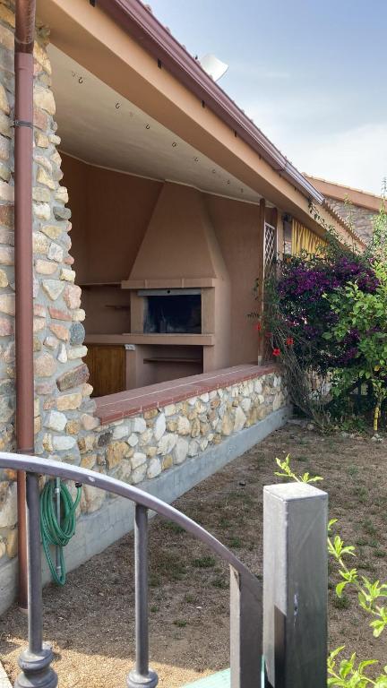 a house with a stone wall and a porch at Villa Michela in Costa Rei