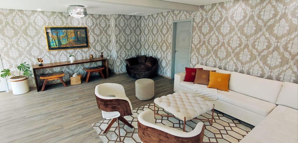 a living room with a white couch and a table at Pousada Serrano in Campos do Jordão