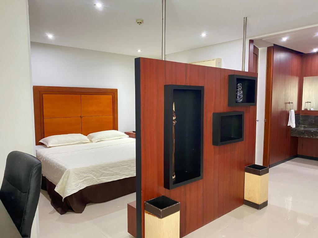 een slaapkamer met een bed en een tv aan de muur bij Atlantic Garden Hotel in Barranquilla