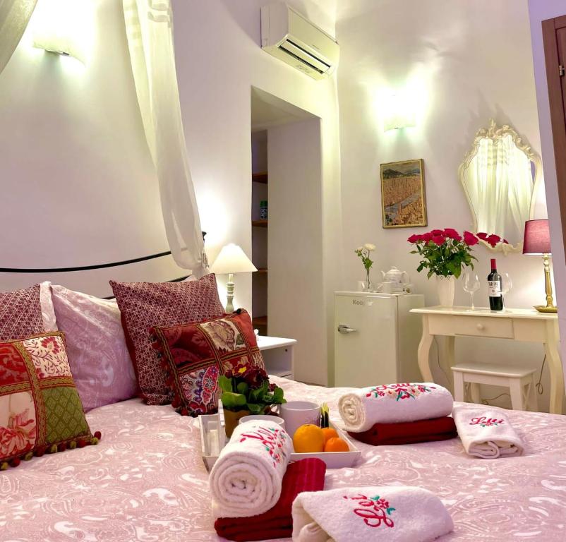 ein Schlafzimmer mit einem Bett mit Handtüchern und Obst darauf in der Unterkunft Home Milù Florence in Florenz