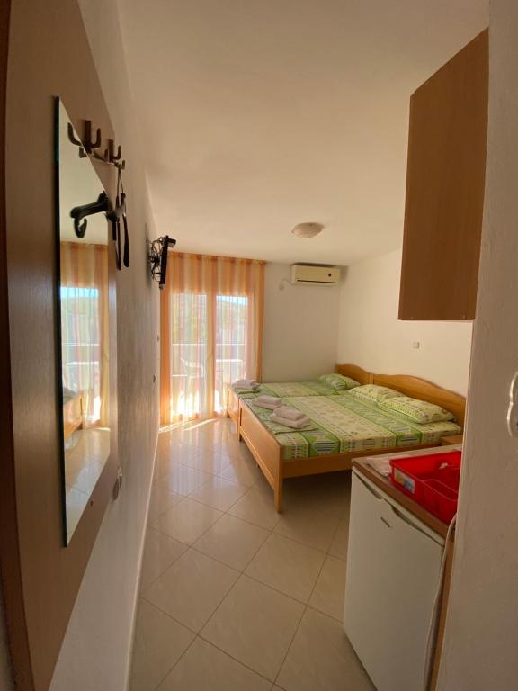 een kleine kamer met 2 bedden en een raam bij Apartments Miladinovic in Sutomore