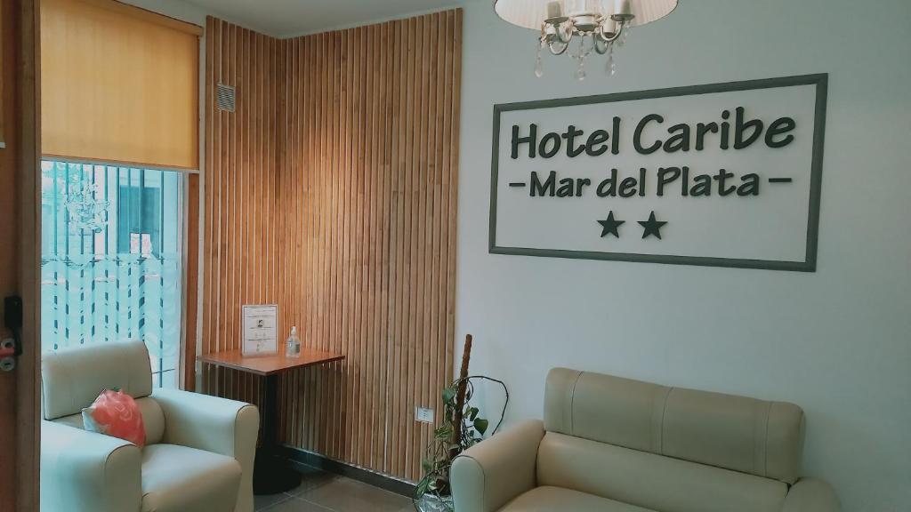 a hotel lobby with a couch and a sign at Hotel Caribe in Mar del Plata
