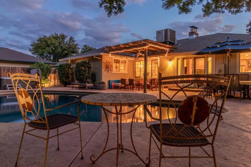 a patio with a table and chairs next to a pool at Elegant River Park Sanctuary in Sacramento