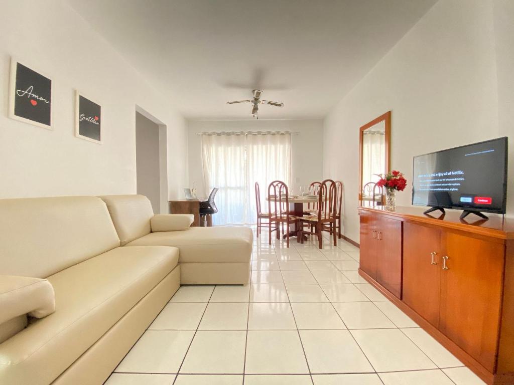 ein Wohnzimmer mit einem Sofa und einem Flachbild-TV in der Unterkunft CB54 - Currasqueira, 2 Dorm Climatizados, Garagem in Balneário Camboriú