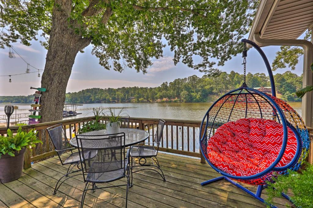 - une balançoire sur une terrasse avec une table et des chaises dans l'établissement Lakefront Hot Springs Home with Swim Dock!, à Hot Springs