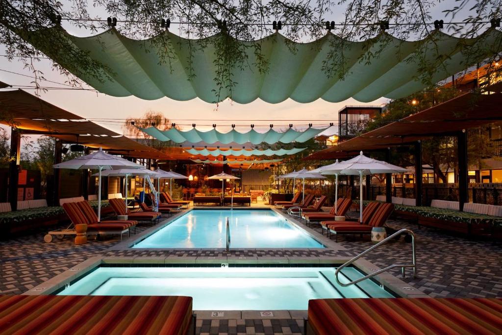 a swimming pool with chairs and umbrellas at RISE Uptown in Phoenix