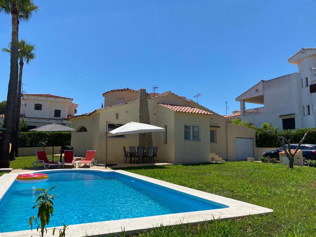 uma piscina em frente a uma casa em Villa Tranquila em Alcossebre