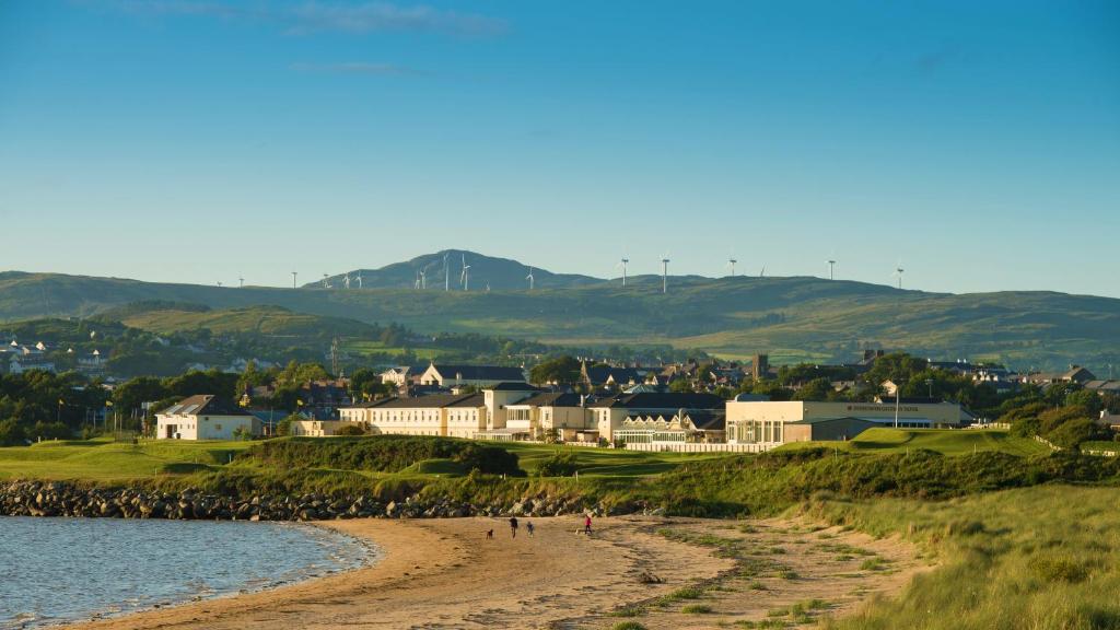 um grupo de pessoas numa praia perto da água em Inishowen Gateway Hotel em Buncrana