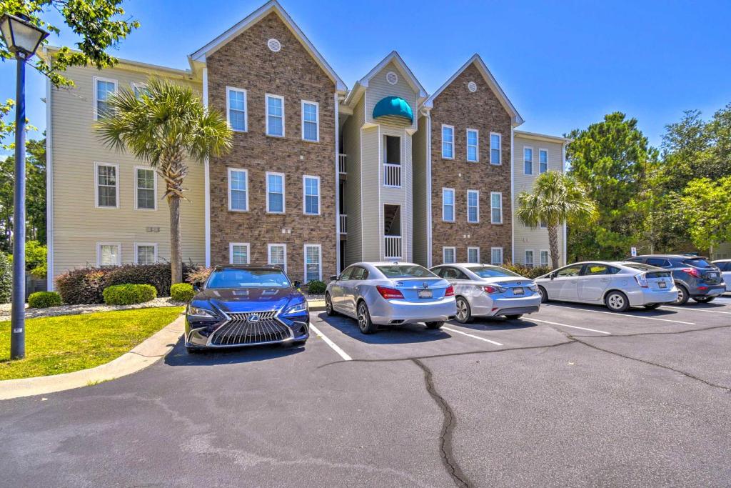eine Gruppe von Autos, die auf einem Parkplatz vor einem Gebäude geparkt sind in der Unterkunft Less Than 2 Mi to Beach Savannah Shores Resort Condo! in Myrtle Beach