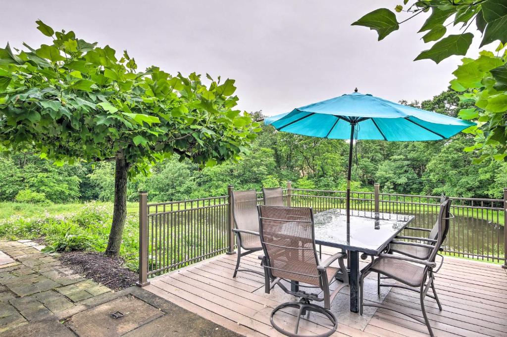OrrvilleMimis Place about Ohio Countryside Duplex with Deck的甲板上配有桌椅和遮阳伞