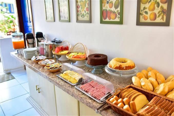 a buffet with many different types of bread and pastries at Hotel Nevada Ubatuba in Ubatuba