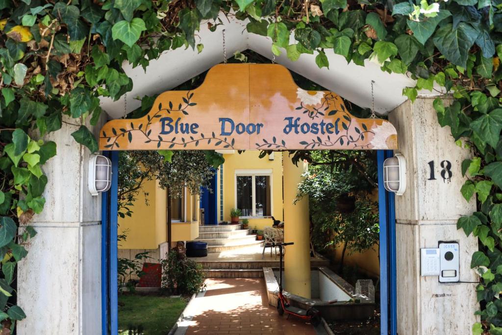 an entrance to a yellow building with a blue door doctor at Blue Door Hostel in Tirana