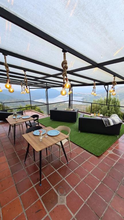a patio with tables and chairs under a canopy at Hostal San Rafael La Calera in La Calera