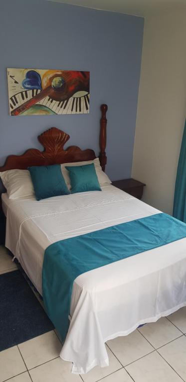 een slaapkamer met een groot bed met blauwe en witte lakens bij Montego Bay westgate Hills jamaica Melrose place in Montego Bay