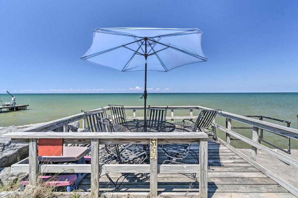 een tafel met stoelen en een parasol op een pier bij Hilton Lake Getaway with Over-the-Water Deck! in Hilton