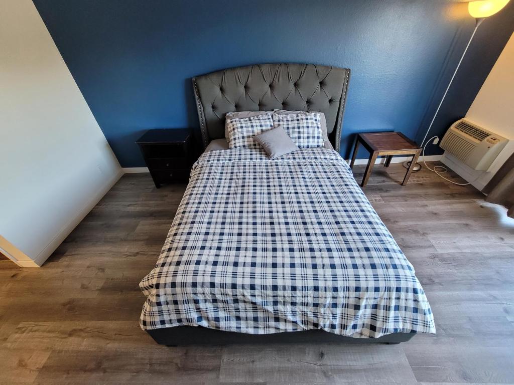uma cama com um cobertor xadrez num quarto em (B26) LA/Beverly Hills Hotel Style Unit em Los Angeles