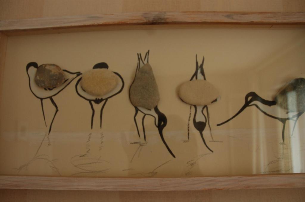 a group of birds on a wall in a wooden frame at Hôtel de L&#39;Avenue in Saintes