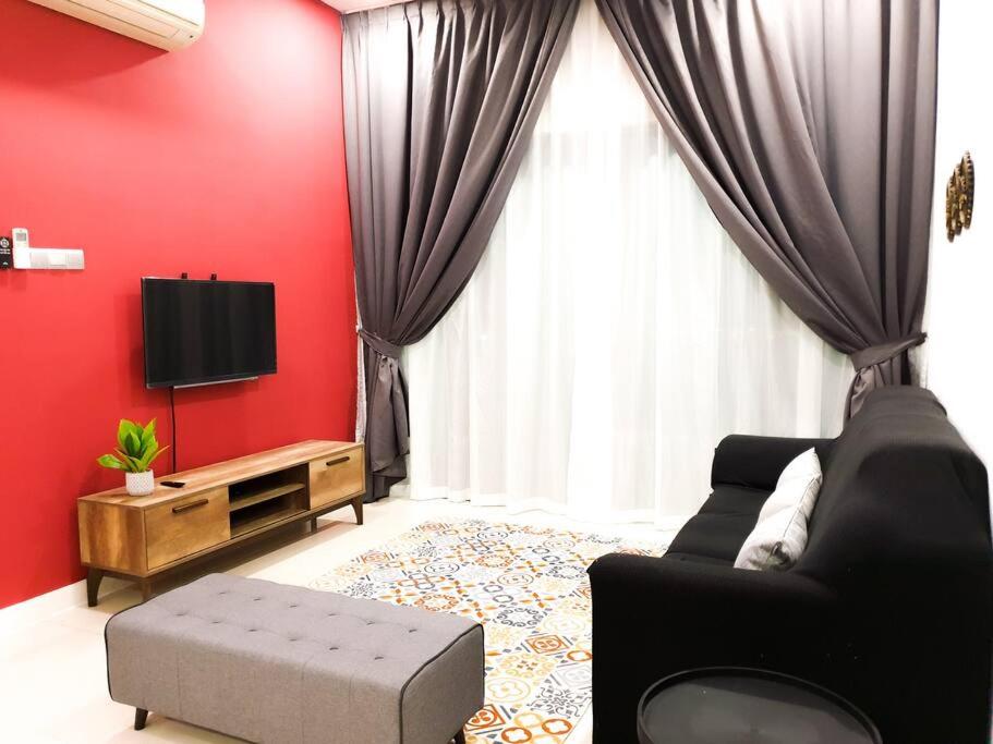 sala de estar de color rojo con sofá y TV en The Loft Imago, Block D - BeOurGuest-, en Kota Kinabalu